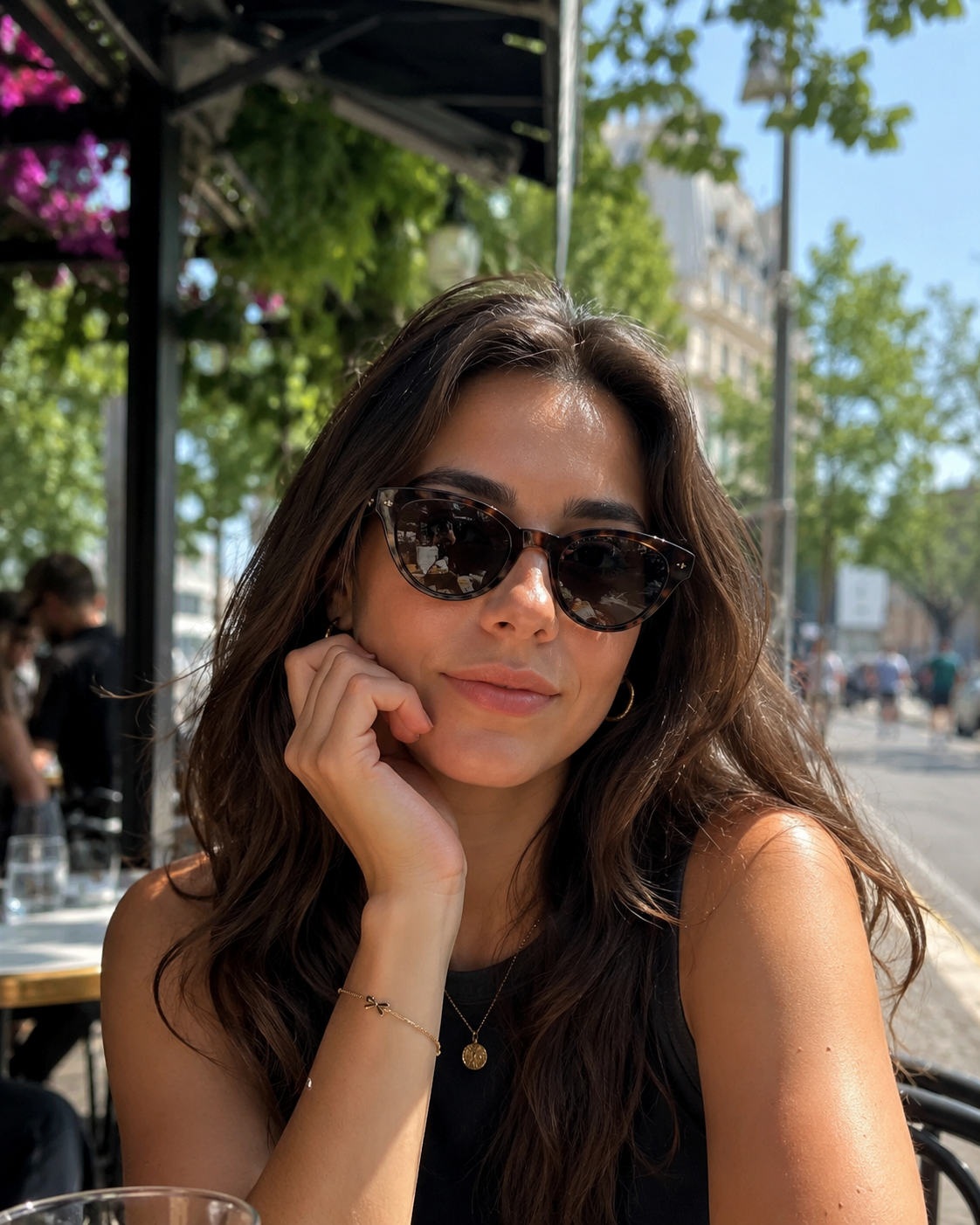Mulher usando óculos de sol de armação tartaruga em um café ao ar livre